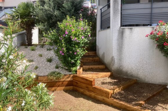 L'Entreprise Aux Charmes du jardin vous propose la création d'un escalier en traverse en chêne et d'un massif à Toussieu
